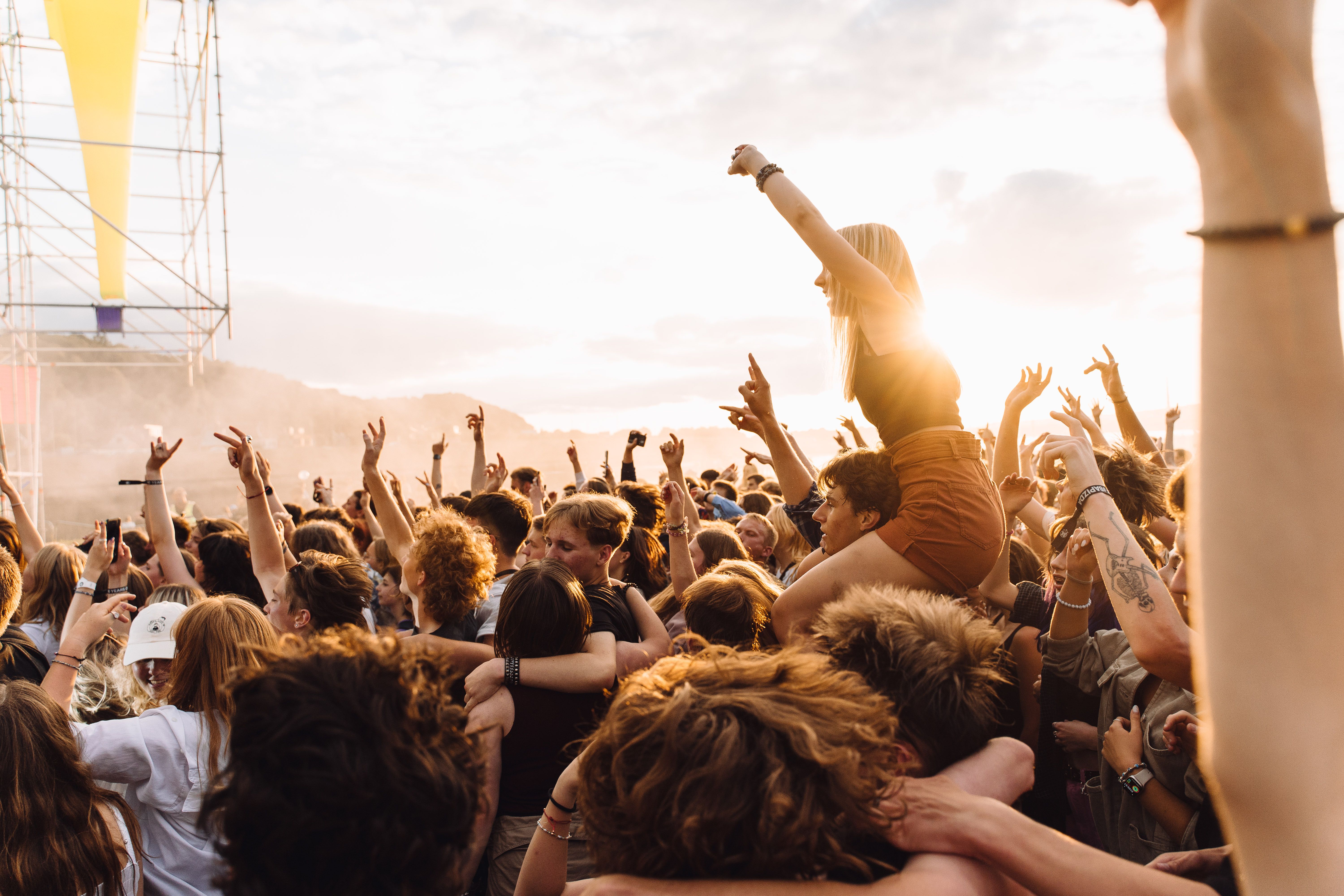 Crowd enjoying a live outdoor concert at sunset