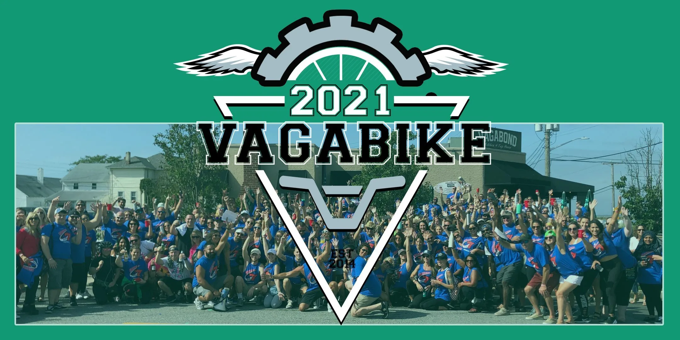 Vagabike 2021 logo over a group photo of riders in blue shirts outside Vagabond